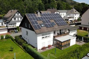 ein Haus mit Sonnenkollektoren auf dem Dach in der Unterkunft Ferienwohnung Niemeier in Hoppecke