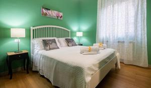 a green bedroom with a large bed with white sheets at LE STANZE DI LUCA in Palermo