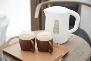 two coffee mugs sitting on a tray next to a blender at BiBi Hotel 波之上 in Naha