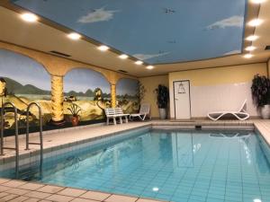 a large swimming pool in a hotel with a mural at Ferienwohnung Royal Walchensee in Walchensee
