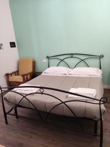 ein Bett mit einem schwarzen Metallrahmen und weißen Kissen in der Unterkunft Loggia Piani Nuovi in Carasco
