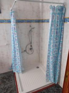 een douche met een douchegordijn in de badkamer bij El Girasol in Arinaga