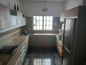 een keuken met een roestvrijstalen koelkast en een raam bij El Girasol in Arinaga