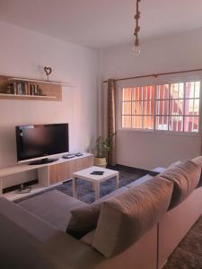 een woonkamer met een bank en een tv bij El Girasol in Arinaga
