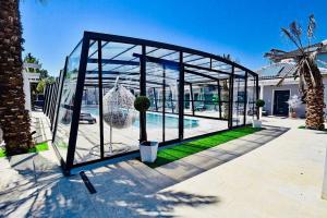 a glass greenhouse with a potted tree in it at אחוזת שקד in Mishmār Hāyardin