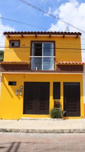 a yellow house with two black garage doors at LA CASA AMARILLA, centrica, barrio local. in Comitán