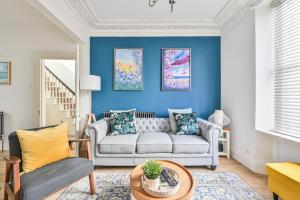 a living room with blue walls and a couch at Luxury Georgian Townhouse Moments from the Harbour in Looe