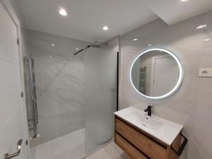 W łazience znajduje się umywalka i lustro. w obiekcie Ordoño II Suites con Aire Acondicionado y Wifi w mieście León