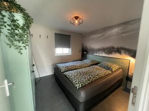 a bedroom with a bed with a cheetah print on the wall at 't Schouws Uusje in Burgh Haamstede