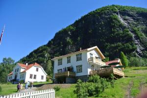 a large house in front of a mountain at Eide Gardshotell in Skjolden