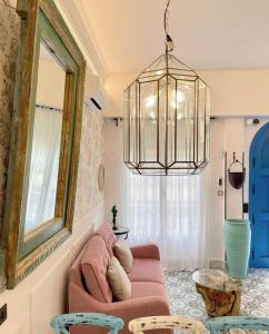 sala de estar con sofá rosa y lámpara de araña en Apartamentos La Puerta Azul 1 El Bajondillo Torremolinos, en Torremolinos