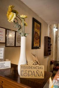un jarrón blanco con flores encima de una mesa en Hotel Residencial España en Salta