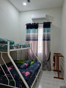 Munirah Homestay في دونجون: غرفة نوم بسريرين بطابقين ونافذة
