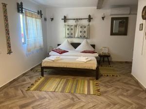 a bedroom with a bed and a wooden floor at Casa Soarelui in Murighiol