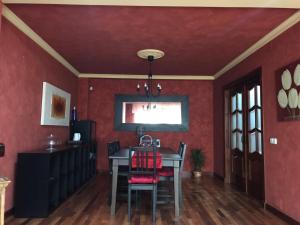 a dining room with red walls and a table and chairs at Los Girasoles in Fuengirola