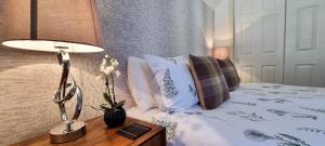 a bedroom with a bed with a lamp and pillows at Heart of Inverness-city apartment in Inverness