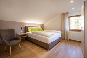 a bedroom with a bed and a chair and a window at Weingut Wolkanhof in Appiano sulla Strada del Vino