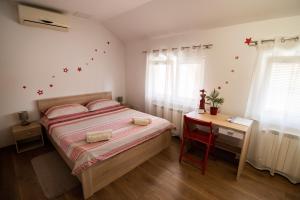 a bedroom with a bed and a desk with a table at Sunny day apartments in Sveta Nedelja