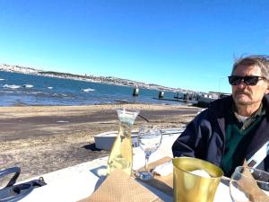 卡帕里卡海岸的住宿－Plage João de Caparica，坐在海滩桌子上的男人