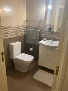 a bathroom with a toilet and a sink at Plage João de Caparica in Costa da Caparica +52 photos