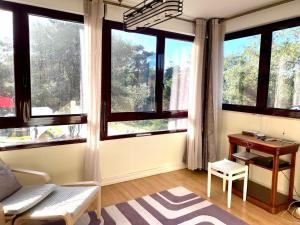 a living room with large windows and a desk at Plage João de Caparica in Costa da Caparica