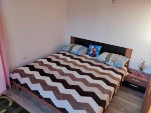a bedroom with a large bed with a brown and white blanket at APARTMAJI GOSTILNA STAR MALN , Sečovlje 10 in Sečovlje