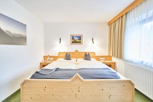 a bedroom with a large wooden bed and a window at Haus Sonnenweg in Leutasch