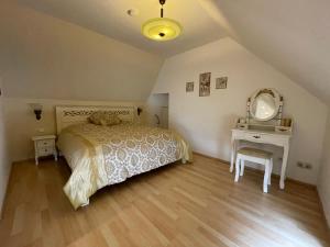 a bedroom with a bed and a vanity and a mirror at Villa Maaremonte in Üdersdorf