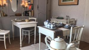une salle à manger avec des tables et des chaises blanches dans l'établissement Les Garçonnières de Sologne, à Salbris