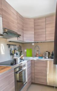 ヴァル・トランスにあるLac Blanc Appartements VTIのキッチン(木製キャビネット、ステンレス製の電化製品付)