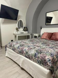 a bedroom with a bed and a tv on a wall at AC HOME in Catania