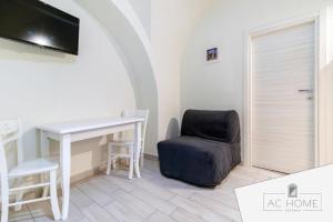 a room with a desk and a chair and a television at AC HOME in Catania