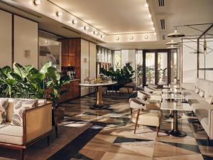 a lobby with tables and chairs and plants at Four Seasons Hotel and Residences Fort Lauderdale in Fort Lauderdale