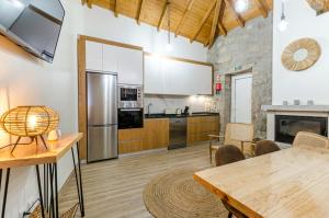 a kitchen and dining room with a table and a refrigerator at Chalet Villas Gerês in Geres