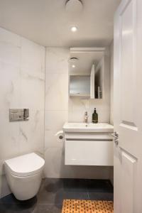 a white bathroom with a toilet and a sink at Period Henley 2 bed apt with parking for 1 car in Henley on Thames