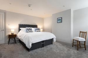 1 dormitorio con 1 cama grande y 1 silla en Period Henley 2 bed apt with parking for 1 car, en Henley on Thames