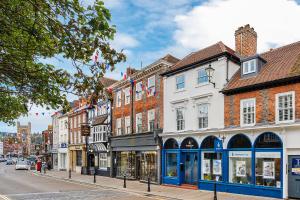 una concurrida calle de la ciudad con edificios y tiendas en Period Henley 2 bed apt with parking for 1 car, en Henley on Thames