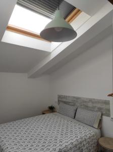 a white bedroom with a bed and a window at EL TESORO DE BACO in Haro