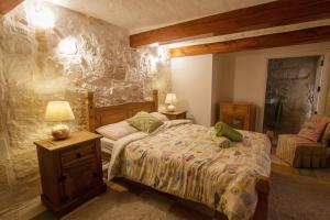 - une chambre avec un lit et un mur en pierre dans l'établissement Town house steeped in history, à Rabat