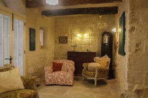 a living room with two chairs and a fireplace at Town house steeped in history in Rabat