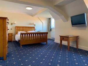 1 dormitorio con 1 cama y TV en la pared en Springfield Country Hotel, Leisure Club & Spa, en Wareham