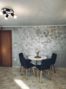 a table with chairs and a vase of flowers on it at Apartments Zaton Draga in Zaton