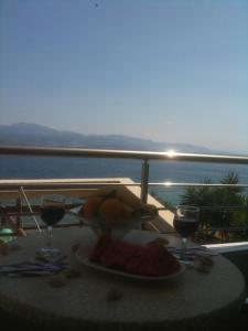 a table with a plate of fruit and two glasses of wine at Almare (Δίκλινο Δωμάτιο 2) in Kato Almiri