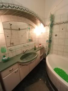 W łazience znajduje się zielona umywalka i wanna. w obiekcie Giardini room w Puli