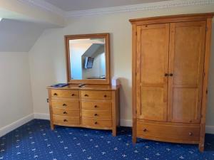 a bedroom with a dresser, mirror, and bed at Springfield Country Hotel, Leisure Club & Spa in Wareham