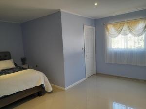 a bedroom with a bed and a window at agradable habitacion privada en casa rural con estacionamiento gratis en sus instalaciones in Chillán