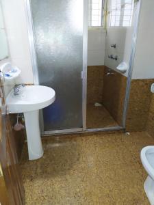ein Bad mit einer Dusche, einem Waschbecken und einem WC in der Unterkunft Hotel Cox's Hilton in Cox's Bazar