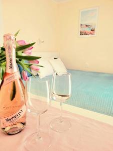 a bottle of champagne and two glasses on a table at Domki Apartamentowe ITALIA in Karwia