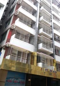wysoki budynek apartamentowy z mnóstwem klatek dla zwierząt w obiekcie Hotel Cox's Hilton w mieście Koks Badźar