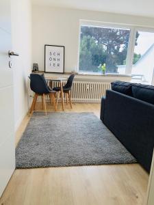 a living room with a couch and a table and a window at Wohnung Skandi-Home ruhige Lage NEU - Düsseldorf Nord in Düsseldorf